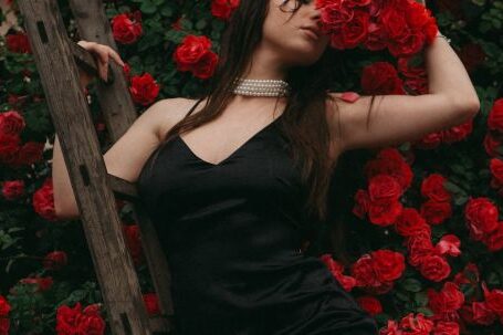 Romantic Fashion - Woman Posing against a Red Rosebush